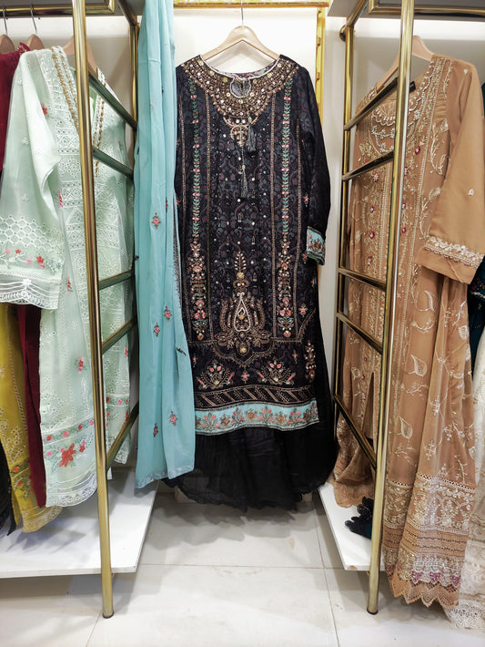 Display of traditional embroidered dresses on hangers in a store.