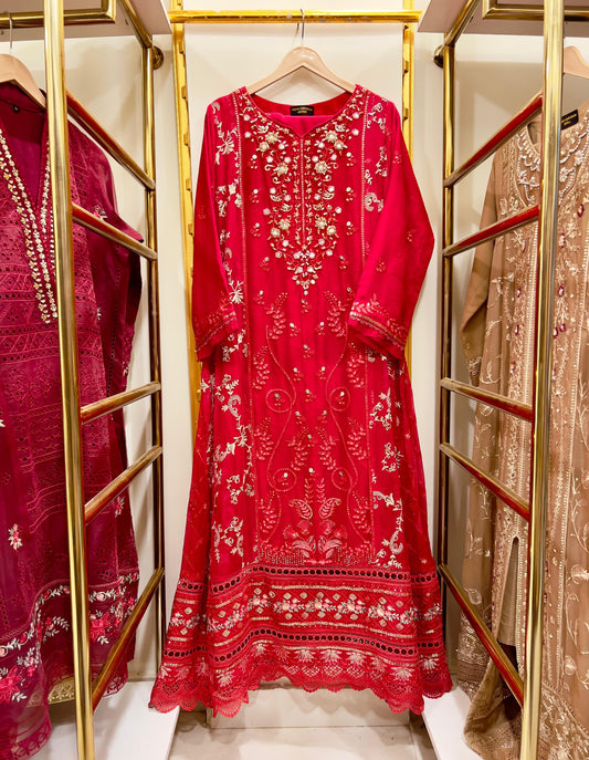Red embroidered  gown dress on a hanger with gold racks and other dresses in the background